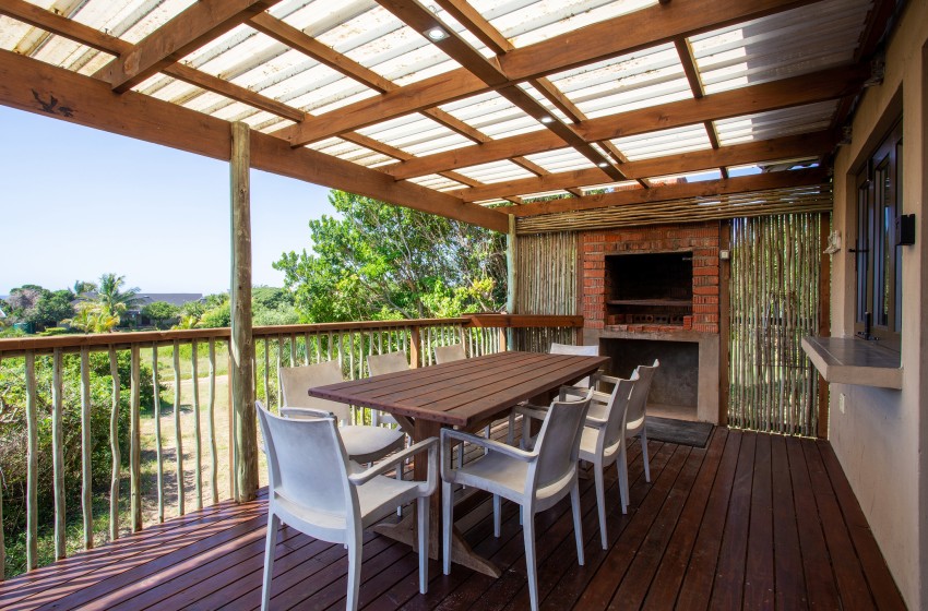 Deck with braai and dining table at Baleia Azul 16 in Ponta Mamoli