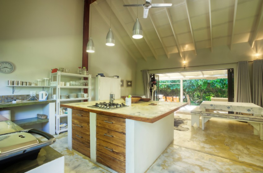 Kitchen with island and bush view at Baleia Azul 26 in Ponta Mamoli