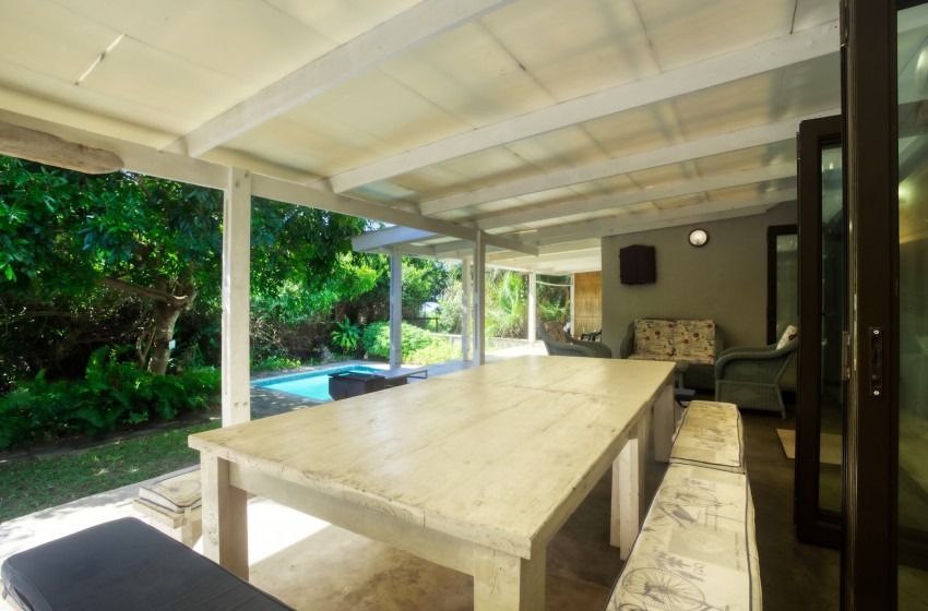Dining table with swimming pool in background at Baleia Azul 26 in Ponta Mamoli