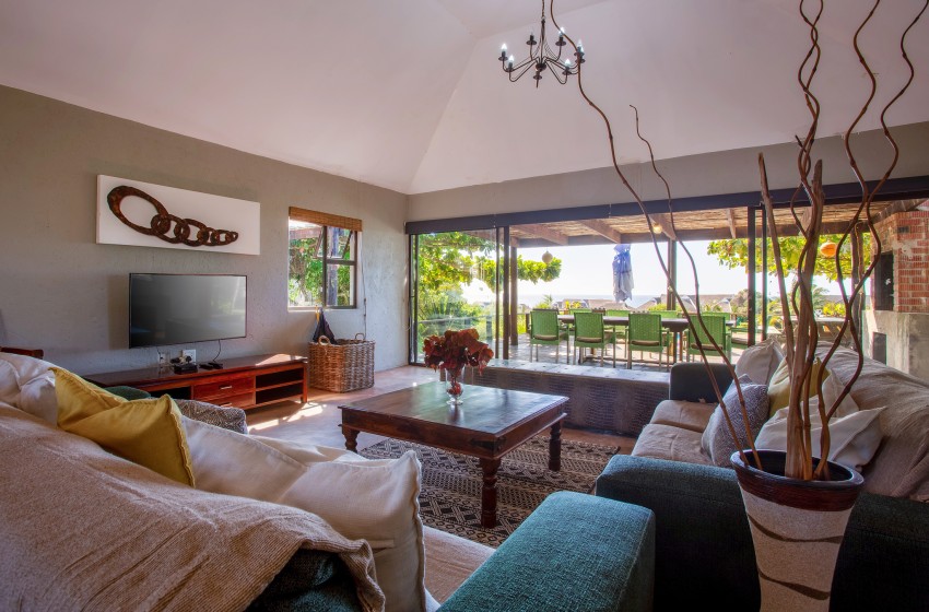 Interior living area overlooking the deck at Baleia Azul 15 in Ponta Mamoli