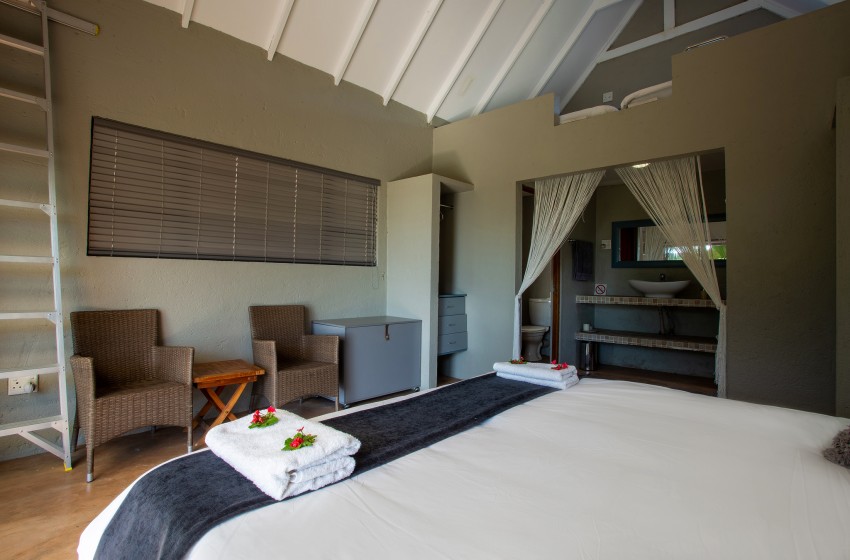 Bedroom 1 with seating at Baleia Azul 15 in Ponta Mamoli
